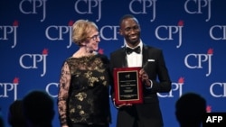 Sandra Mims Rowe, left, and Maxence Melo Mubyazi pose onstage at the Committee to Protect Journalists' 29th Annual International Press Freedom Awards, Nov. 21, 2019 in New York.