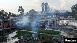 Víctimas del terremoto de Nepal son cremados a la orilla de un río en Karmandú, la capital.