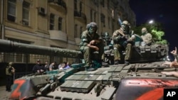 Anggota militer Grup Wagner duduk di atas tank di jalan di Rostov-on-Don, Rusia, Sabtu, 24 Juni 2023. Inggris akan menyatakan kelompok tentara bayaran Wagner Rusia itu sebagai organisasi teroris terlarang. (Foto: AP)