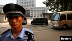 A minivan believed to be carrying disgraced Chinese politician Bo Xilai (C) arrives at the Jinan Intermediate People's Court ahead of Bo's fourth-day trial in Jinan, Shandong province Aug. 25, 2013.