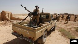 FILE - Iraqi troops monitor an area west of the shrine city of Karbala, in central Iraq, June 29, 2014. 