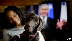 Alicia Barnett sits with her Chocolate Labrador Retriever named "Mueller" in their Kansas City, Kan., home on March 11, 2019. 
