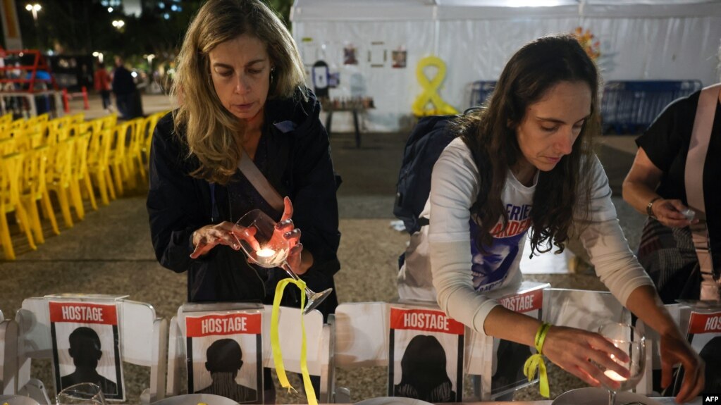 Mujeres preparan una mesa simbólica durante una manifestación en Tel Aviv exigiendo la liberación de los israelíes rehenes en la Franja de Gaza, el 21 de noviembre de 2023, en medio de las batallas en curso entre Israel y los palestinos.