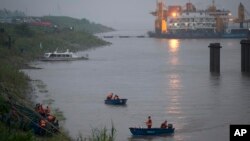 ທະຫານຈີນ ກຳລັງຂີ່ເຮືອ ຈອດຢູ່ເຂື່ອນ ຫລັງຈາກໄດ້ປະຕິບັດງານ ຊອກຫາຜູ້ເຄາະຮ້າຍເຮືອຫລົ້ມ. 