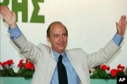 FILE - Then-Greek Premier Costas Simitis, waves to his Socialist party delegates who elected him June 30, 1996, as party chairman.