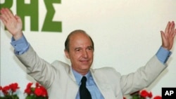 FILE - Then-Greek Premier Costas Simitis, waves to his Socialist party delegates who elected him June 30, 1996, as party chairman.