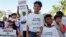 Hector Rivera, 8, Mario Jordan Micael, 3, and Ramon Montes, 5, participate in a rally in West Palm Beach, Fla., Sept. 22, 2018, marking the one-year anniversary of Hurricane Maria's devastation of Puerto Rico.