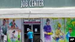 En esta foto de archivo del 7 de mayo de 2020, una persona mira dentro de las puertas cerradas del Centro de Trabajo Comunitario de Pasadena en Pasadena, California, durante el brote de coronavirus.