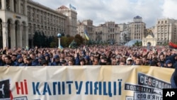 Protesters hold a banner that reads: "No Capitulation" as they gather in Independence Square in Kyiv, Ukraine, Oct. 6, 2019.