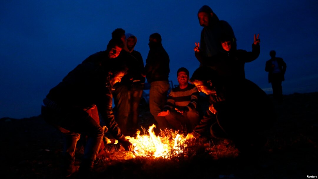 Turkish Kurds sit around a fire to warm themselves as they watch the Syrian town of Kobani from a hill near the Mursitpinar border crossing, on the Turkish-Syrian border in the southeastern town of Suruc, Turkey, Oct. 22, 2014.