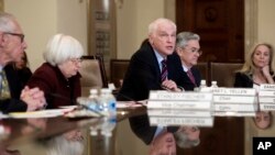 FILE - Federal Reserve Board member Daniel Tarullo, center, accompanied by Chair Janet Yellen (2nd left) Vice Chair Stanley Fischer (left), Jerome Powell, (2nd right) and Lael Brainard (right) during an open board meeting in Washington, Dec. 15, 2016.