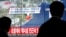 韩国人走过播放朝鲜核基地附近发生地震的有关消息的屏幕。 （2016年1月6日）	