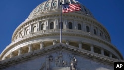 FILE - The flag waves in front of the U.S. Capitol Building in Washington, Nov., 19, 2011.