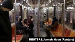 Warga AS mengenakan masker saat menaiki kereta bawah tanah di kota New York (foto: dok). 