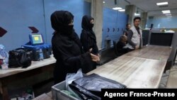 Afghan women airport workers are pictured at a security checkpoint in the airport in Kabul on Sept. 12, 2021.