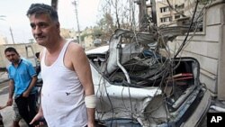 A Christian Iraqi man stands close to his destroyed vehicles parked close to the Sayidat al-Nejat Catholic cathedral, in central Baghdad, 1 Nov 2010