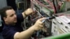 FILE - Network engineer Will Duquette adjusts wires at Great Works Internet in Biddeford, Maine, April 6, 2010. The so-called Three Ring Binder project will bring ultra-fast connections to Great Works and other Maine internet service providers that need b