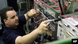 FILE - Network engineer Will Duquette adjusts wires at Great Works Internet in Biddeford, Maine, April 6, 2010. The so-called Three Ring Binder project will bring ultra-fast connections to Great Works and other Maine internet service providers that need b