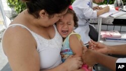 In this March 2, 2018 photo, a child cries out as she is given a vaccine against yellow fever at a public health post set up on the outskirts of Sao Paulo, Brazil. (AP Photo/Andre Penner)