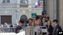 Opposition activist Maria Baronova, center right, and other people queue to get to an office of the presidential administration during a protest in downtown Moscow, Russia, Saturday, April 29, 2017. 