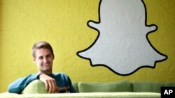 Le PDG de snapchat Evan Spiegel devant le logo de son entreprise le 24 octobre 2013. 
