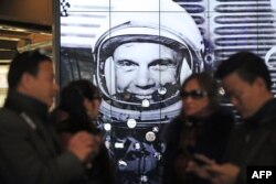 Tourists gather near a tribute to former astronaut and U.S. Senator John Glenn, at the National Air and Space Museum, Dec. 9, 2016 in Washington, D.C.