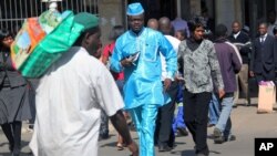 People walk down a street in the capital city of Zimbabwe, Harare, July, 12, 2012.