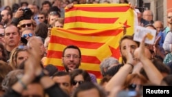 Protesters hold Esteladas (Catalan separatist flags) during a rally in favor of a planned referendum on the independence of Catalonia in Madrid, Spain, Sept. 17, 2017.