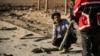 Syrians look for unexploded ammunition at the site of the previous evening's Israeli airstrike that targeted shipments of weapons that belonged to Syrian government forces in Qamishli, in mainly Kurdish northeastern Syria, on December 10, 2024.