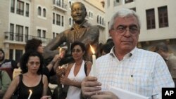 Lebanese activists carry candles during a candle vigil in support of the Syrian people in Beirut, Lebanon, July 31, 2011