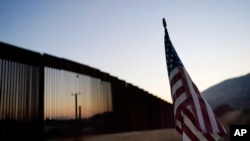 Una bandera estadounidense ondea frente al muro fronterizo que separa a EE.UU. y México, el 24 de septiembre de 2020.