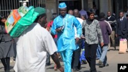 FILE: People walk down a street in the capital city of Zimbabwe, Harare, July, 12, 2012.