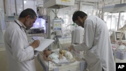 USAID presta ayuda a médicos afganos los cuales revisan a los bebes que reciben tratamiento médico en el hospital infantil Indira Gandhi y la sala de neonatos en Kabul, Afganistán.