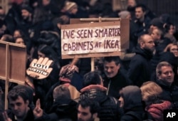 A man holds a banner during a protest in Bucharest, Romania, Nov. 26, 2017.