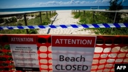 FILE - A closed beach signage is seen at Coolangatta Beach on the Queensland - New South Wales border in Brisbane on April 15, 2020. 