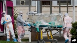 Un patient dans une unité de bioconfinement est transporté sur une civière depuis une ambulance arrivée à l'hôpital Columbus Covid 2 à Rome (Italie), le 17 mars 2020. (Photo: AP)