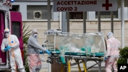 A patient in a biocontainment unit is carried on a stretcher from an ambulance arrived at the Columbus Covid 2 Hospital in Rome, March 17, 2020.