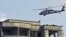 Un helicóptero de la OTAN sobrevuela el ediificio que los combatientes del Talibán iocuparon durante el ataque.