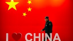 安保人员从中国国旗和“我爱中国”标志旁走过。