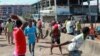 Peul youths throw stones toward members of the Malinke ethnic group, during clashes between Malinke and Peul shopkeepers in Conakry, Guinea, Sept. 21, 2012. 