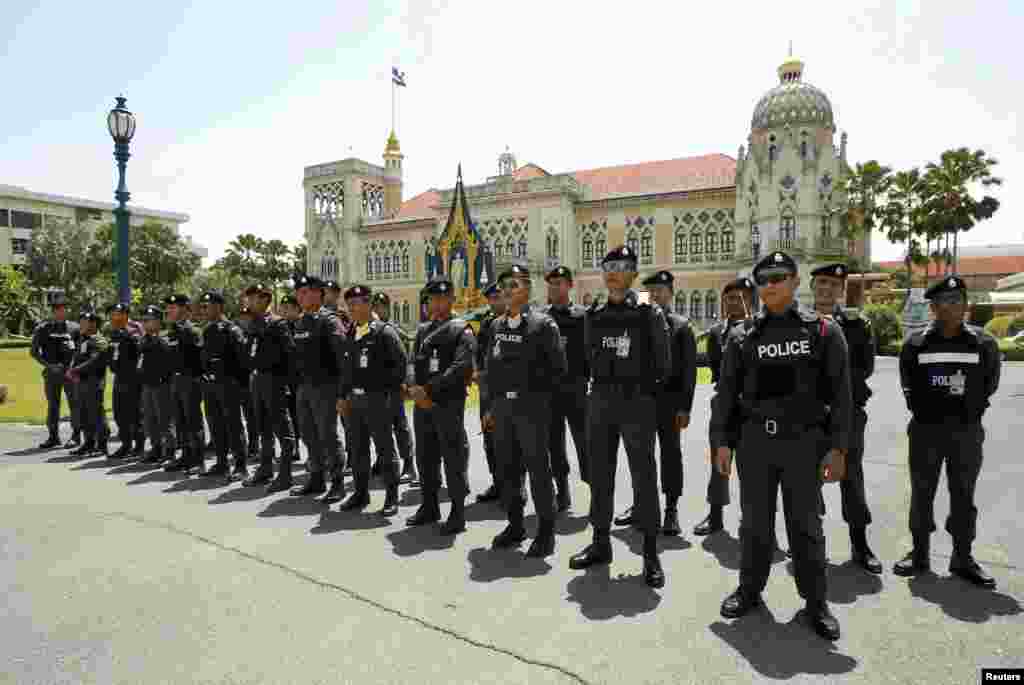 Policemen stand guard at the Government House during an anti-government rally, in Bangkok, May 9, 2014.
