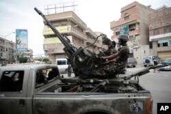 FILE - Soldiers loyal to Shiite tribesmen, known as Houthis, guard a street during a rally in support of the Houthi movement in Sana'a, Yemen, July 18, 2016.