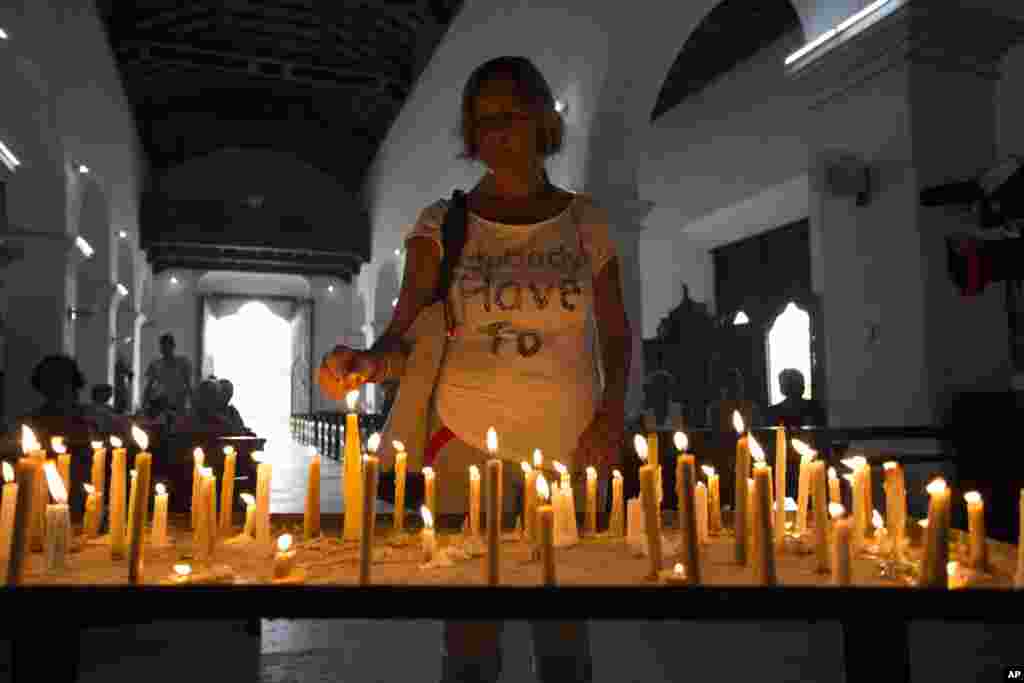 A woman prays at a church for protection against Hurricane Irma, in Caibarien, Cuba. Cuba evacuated tourists from beach resorts after Irma left thousands homeless on a devastated string of Caribbean islands and spun toward Florida.