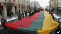 Lithuanians march during a celebration of the 20th anniversary of the "Battle for the Freedom of Nations" carrying a 200m long sash in the Lithuanian flag colors from the Cathedral Square to the Independence Square in Vilnius, Lithuania, 13 Jan 2011