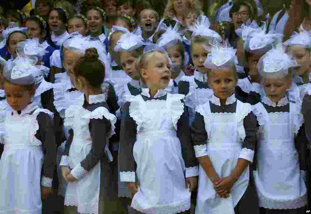 Schoolgirls in traditional uniforms attend a ceremony on the occasion of the first day of school at a cadet lyceum in Kyiv, Ukraine.