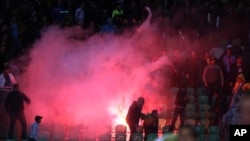Flares are thrown in the stadium during deadly clashes that erupted after a football match between Egypt's Al-Ahly and Al-Masry teams in Port Said, Egypt, February 1, 2012.