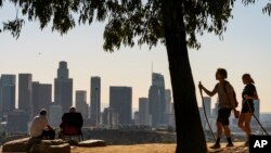 FILE - In this Monday, Jan. 11, 2021, file photo, people overlook the skyline of Los Angeles. California is losing a U.S. House seat for the first time, dropping its delegation from 53 to 52 members.
