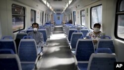Dos pasajeros usan mascarillas en un vagón vacío del metro de Buenos Aires, al cumplirse el primer día de cuarentena general. 