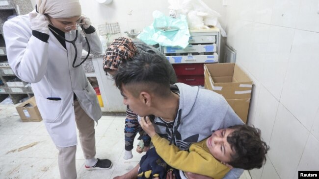 A Palestinian holds a child wounded in an Israeli strike at Nasser Hospital, amid the ongoing conflict between Israel and the Palestinian Islamist group Hamas, in Khan Younis in the southern Gaza Strip Jan. 22, 2024.