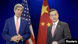 China's Foreign Minister Wang Yi (R) listens while US Secretary of State John Kerry talks before a bilateral meeting at the Putra World Trade Center Aug. 5, 2015 in Kuala Lumpur, Malaysia.